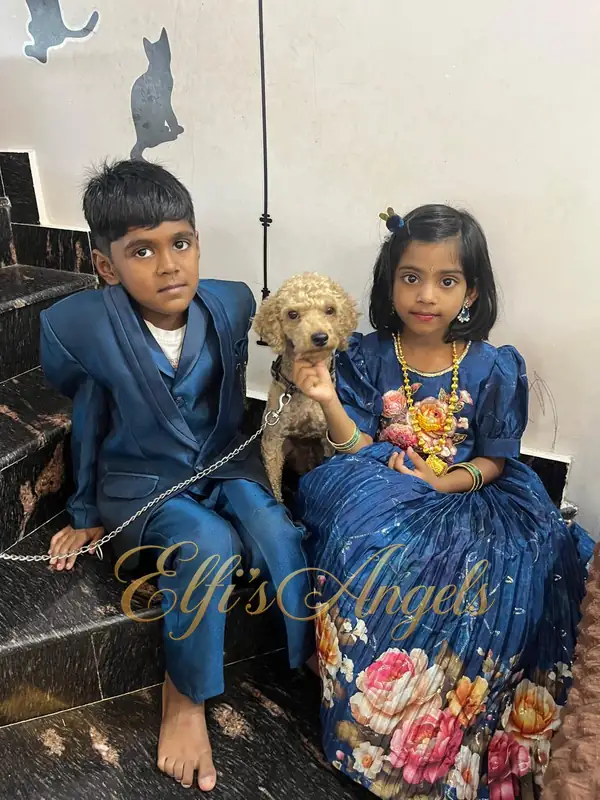 Iniyan sitting with two children in their celebration clothes